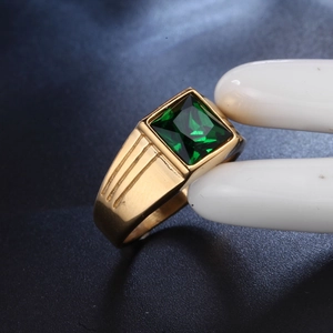 Detail of a square green gemstone ring with a gold band and triple grooved accents