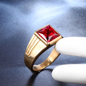 Close-up of a men's gold titanium ring with a large square ruby red gemstone inlay