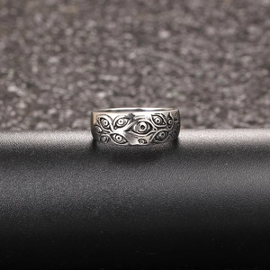 Macro detail of gothic stainless steel band ring featuring embossed evil eye patterns