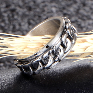Men's stainless steel spinner ring featuring a rotatable Cuban chain on black textured surface