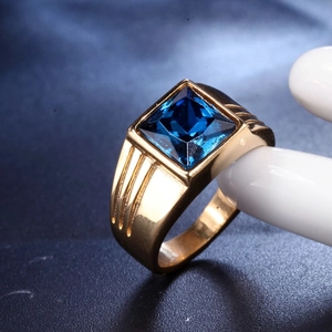 Macro shot of gold men's titanium ring featuring a square blue gemstone inlay detail