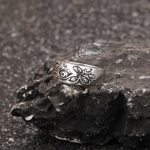 Macro shot of stainless steel evil eye ring with gothic embossed relief and dark patina