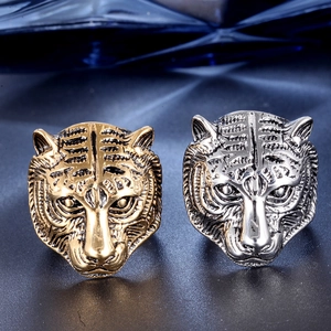 Detail of gold and silver tiger head rings featuring intricate embossed metal textures