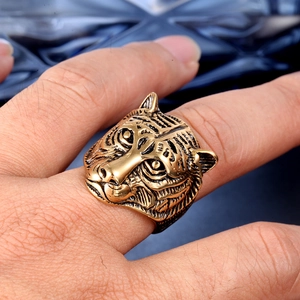 Close-up of vintage golden tiger head ring with detailed engraving on model's hand