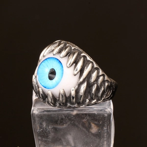Macro detail of gothic stainless steel ring featuring a realistic blue eyeball setting