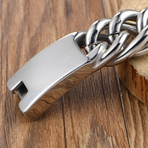 Men's chunky titanium steel Cuban link bracelet with rectangle clasp on wood background