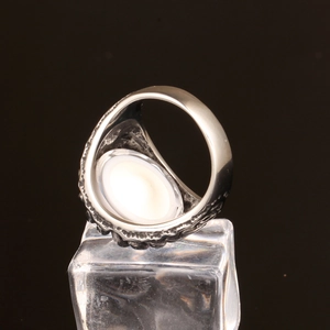 Detail of vintage silver rings with black oxidation and an oval white gemstone inlay