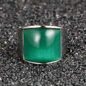 Bague en acier inoxydable avec une grande pierre œil-de-chat verte sur fond noir