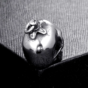 Macro shot of polished stainless steel apple pendant with star detail on black leather background