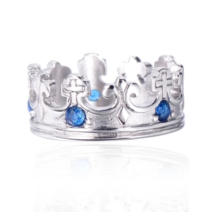 Detailed view of vintage silver crown ring featuring blue gems and cross cutout patterns