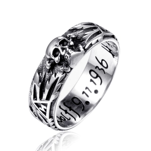 Detailed close-up of a punk skull ring featuring an engraved date and vintage oxidized finish