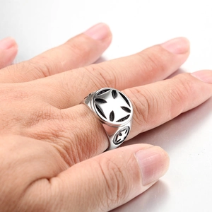 Close-up of vintage stainless steel cross shield ring with gothic punk design