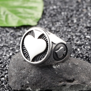 Detail shot of vintage punk rock signet ring with King of Spades motif on a rock surface