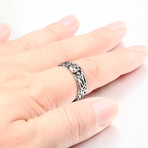 Detail of vintage punk skull ring on hand showing gothic antique silver finish