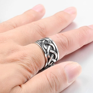 Macro shot of silver Celtic knot embossed texture on men's heavy stainless steel ring