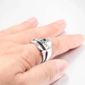 Vue détaillée d'une bague en acier titane argenté avec gravure LUCKY portée au doigt