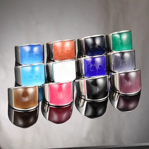 Macro shot of wide stainless steel rings with colorful rectangle gemstones and reflections