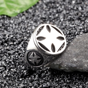 Vintage stainless steel cross ring for men on rustic natural stones and green leaf
