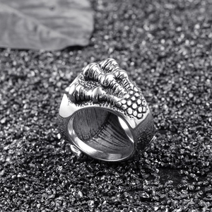 Punk style dragon claw ring in vintage silver finish on dark mineral background