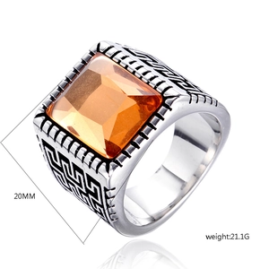 Macro view of men's steel ring with 20mm wide band and orange square-cut gemstone
