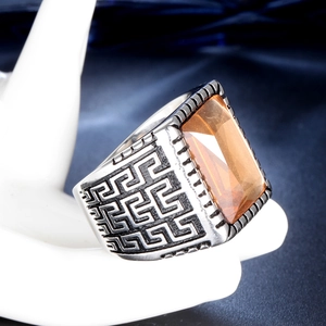 Vintage stainless steel ring featuring amber stone and Greek key pattern on hand model