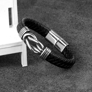 Men's black braided leather bracelet with silver knot detail and magnetic clasp