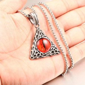 Detailed view of hip hop stainless steel pendant with red eye detail and vintage texture