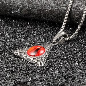 Macro view of hip hop stainless steel pendant featuring a realistic red dragon eye stone