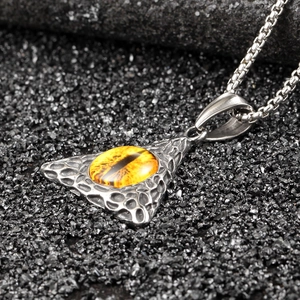Macro detail of silver hip hop pendant with yellow dragon eye stone and lava texture
