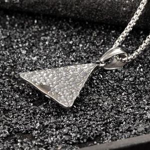 Detailed macro of silver stainless steel triangle pendant with hammer texture on black stones