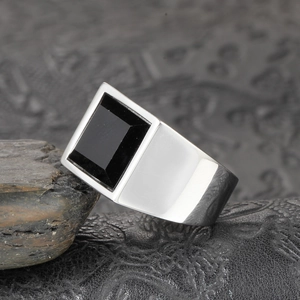 Vue macro d'une bague large pour homme avec pierre noire rectangulaire sur cuir noir