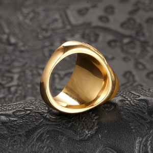 Men's titanium steel gold ring with textured exterior on luxury black leather base