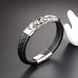 Detail of black braided leather men's bracelet featuring embossed steel chain inlay