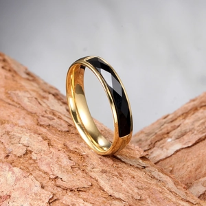 Vue macro d'une bague dorée avec insert noir sur un support en écorce naturelle