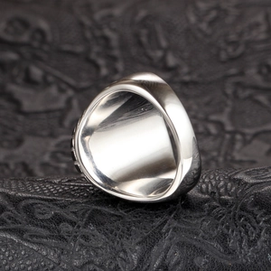 Anillo de plata pulida para hombre sobre cuero negro con acabado de espejo de alta calidad