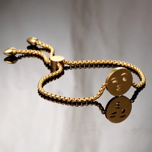 Macro detail of gold-plated penguin charm on an adjustable slider chain bracelet