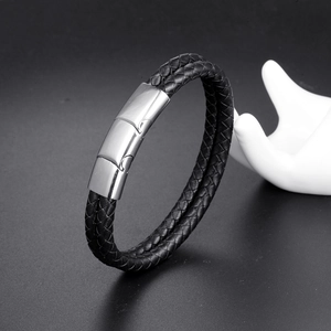 Detail of double-braided black leather strap and polished stainless steel buckle on men bracelet
