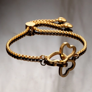 Detailed view of the gold heart bracelet with adjustable slider and twin heart charms