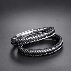 Detailed macro of black braided leather bracelets featuring silver magnetic stainless steel clasps