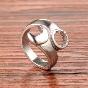 Industrial style stainless steel wrench shaped open ring for men on a wood background