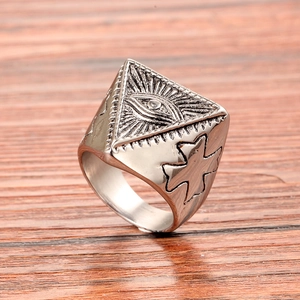 Macro detail of silver stainless steel ring with Eye of Providence and cross engraving