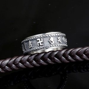 Anello rotante vintage in acciaio al titanio con simboli religiosi su sfondo nero