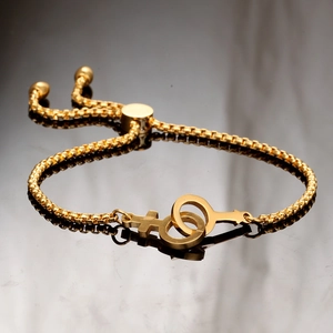 Macro detail of golden box chain bracelet with double female symbol pendant and slide clasp
