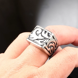 Close-up of a mens vintage punk steel ring featuring black tribal swirl patterns on finger