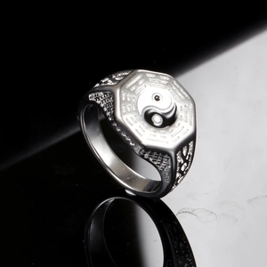 Gros plan de la bague en acier inoxydable avec motif Yin Yang Bagua et texture grillagée