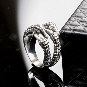 Gothic punk men's silver claw ring with textured dragon scales on reflective black surface