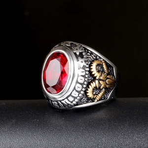 Macro detail of men's vintage steel ring with red gemstone and gold ram head carving