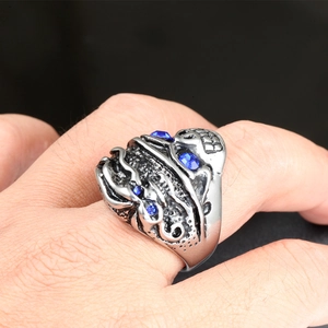 Dettaglio anello teschio vintage da uomo in argento con pietre blu incastonate