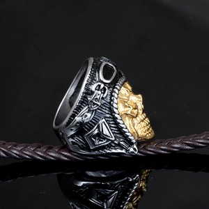 Detail view of vintage stainless steel skull ring with gold relief and aviator goggles