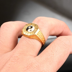 Gros plan sur une chevalière octogonale dorée avec symbole Tai Chi Yin Yang bicolore
